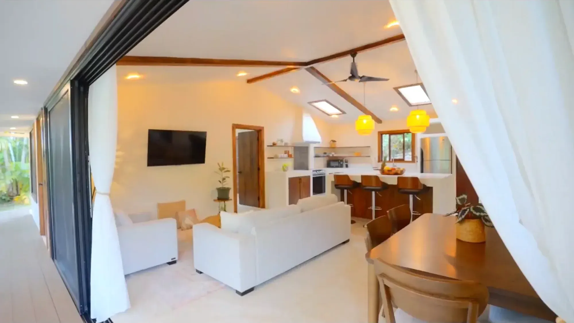 Light-filled living area with vaulted wood beam ceilings in the Costa Rica luxury home